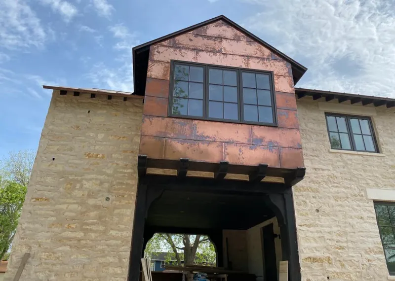 Copper metal panel facade on a stone building for Skylight Installation in Marvin